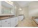Spacious bathroom with double vanity, granite counters, and large soaking tub with tile surround at 2981 Sturbridge Rd, Mount Pleasant, SC 29466