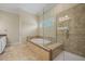Bright bathroom featuring glass enclosed shower, tub and neutral tile at 2981 Sturbridge Rd, Mount Pleasant, SC 29466