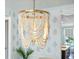 Close-up shot of dining room's stunning beaded chandelier with patterned wallpaper in the background at 2981 Sturbridge Rd, Mount Pleasant, SC 29466