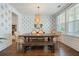 Dining room with beaded chandelier, blue wallpaper, farmhouse table, and bench seating at 2981 Sturbridge Rd, Mount Pleasant, SC 29466