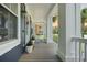 Covered front porch featuring white columns, rocking chairs, and decorative plants at 2981 Sturbridge Rd, Mount Pleasant, SC 29466