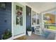 Inviting front porch with rocking chairs, a colorful wreath, and blue accent door at 2981 Sturbridge Rd, Mount Pleasant, SC 29466