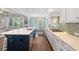 Bright open-concept kitchen with white cabinets, blue island, stainless steel appliances, and hardwood floors at 2981 Sturbridge Rd, Mount Pleasant, SC 29466