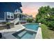 Beautiful backyard pool and hot tub with an umbrella, lounge chairs, and a screened-in back porch at 2981 Sturbridge Rd, Mount Pleasant, SC 29466