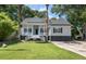 Charming home featuring a welcoming front porch, white columns, and a well-manicured lawn at 3872 James Bay Road, Johns Island, SC 29455