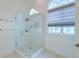 Modern bathroom featuring a glass shower with white subway tile and an arched window at 401 Felders Ln, Johns Island, SC 29455