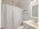Bright bathroom with white fixtures, a shower curtain, and glass shelving at 401 Felders Ln, Johns Island, SC 29455