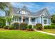 Charming exterior with landscaped yard, inviting front porch, and classic blue siding at 401 Felders Ln, Johns Island, SC 29455