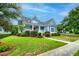 Charming blue home with landscaped yard, walkway, and mature trees at 401 Felders Ln, Johns Island, SC 29455