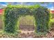 Vine-covered archway frames a wooden swing, creating a whimsical and enchanting backyard feature at 427 Grape Arbor Drive Dr, Summerville, SC 29486