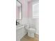 Modern bathroom with pink striped walls, a pedestal sink, and wainscoting at 428 Bluegill Ln, Johns Island, SC 29455