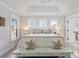 Bright bedroom with beach decor features a tray ceiling, bench, and ensuite bathroom with tiled shower at 428 Bluegill Ln, Johns Island, SC 29455