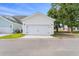A detached two car garage with white doors, black hardware and a well kept lawn at 428 Bluegill Ln, Johns Island, SC 29455