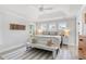Bright bedroom features a tray ceiling, three windows, and wooden floors at 428 Bluegill Ln, Johns Island, SC 29455