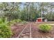 Landscaped backyard with stone pathway, pool, metal building and plenty of trees at 4352 Park Island Rd, Hollywood, SC 29449