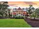 Charming two-story red home with a metal roof, inviting front porch, and a well-maintained lawn at 4352 Park Island Rd, Hollywood, SC 29449