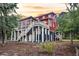 Exterior view of a red multi-story home with expansive decking and wooded surroundings at 4352 Park Island Rd, Hollywood, SC 29449