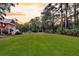 Expansive front yard featuring lush green lawn, mature trees, and a charming two-story home in the background at 4352 Park Island Rd, Hollywood, SC 29449