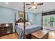 Comfortable main bedroom with hardwood floors, blue walls, four-poster bed, and outdoor access through glass doors at 4352 Park Island Rd, Hollywood, SC 29449