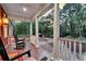 Inviting front porch with rocking chairs and a view of the lush, wooded surroundings at 4352 Park Island Rd, Hollywood, SC 29449