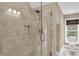 Modern bathroom shower featuring glass door, neutral tile surround, and recessed shelf at 4352 Park Island Rd, Hollywood, SC 29449