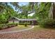 Charming single-story brick home with a two-car garage surrounded by mature trees and a welcoming front walkway at 4822 Parker Dr, North Charleston, SC 29405