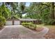 Inviting brick ranch-style home with a two-car garage, a driveway and lush greenery providing shade and privacy at 4822 Parker Dr, North Charleston, SC 29405