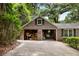Brick two-car garage with concrete driveway, surrounded by shady trees and Spanish moss at 4822 Parker Dr, North Charleston, SC 29405