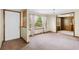 Bright living room with neutral walls, carpet, large windows, a chandelier, and an adjoining room with wood paneling at 4822 Parker Dr, North Charleston, SC 29405