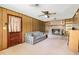 Cozy living room with wood paneled walls, a brick fireplace with built-in shelving, and a plaid couch at 4822 Parker Dr, North Charleston, SC 29405