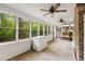 Sunroom with many large windows, brick and paneled walls, a ceiling fan, and linoleum flooring at 4822 Parker Dr, North Charleston, SC 29405