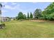 A spacious backyard features a lush lawn, manicured hedges, and mature trees for privacy and tranquility at 513 Sea Foam St, Summerville, SC 29486
