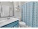 The blue and white bathroom features a vanity, toilet, shower with blue patterned curtain, and a large framed mirror at 513 Sea Foam St, Summerville, SC 29486