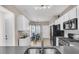 Open-concept kitchen featuring modern appliances, white cabinets, a breakfast bar, and a cozy breakfast nook at 513 Sea Foam St, Summerville, SC 29486