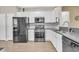 Modern kitchen with stainless steel appliances, white cabinets, granite countertops, and wood-look flooring at 513 Sea Foam St, Summerville, SC 29486