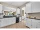 Modern kitchen features white cabinets, gray countertops, updated appliances, and access to other rooms at 513 Sea Foam St, Summerville, SC 29486