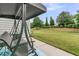 This backyard patio features a porch swing, with views of the lush lawn, manicured hedges, and mature trees at 513 Sea Foam St, Summerville, SC 29486