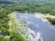 Scenic aerial shot of the lake's tranquil waters reflecting the sky, surrounded by trees and lily pads at 617 Deepwood Ct, Moncks Corner, SC 29461