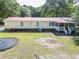 Spacious backyard with a red metal roof home, trampoline, and lawn mower at 617 Deepwood Ct, Moncks Corner, SC 29461