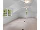 Spacious attic features neutral carpet, paneled walls, dormer windows, and modern fans at 6464 Saint Anthony Dr, Meggett, SC 29449