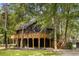 Two-story home featuring wood exterior and large deck surrounded by mature trees at 6464 Saint Anthony Dr, Meggett, SC 29449