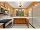 Cozy kitchen featuring oak cabinets, tiled backsplash, white countertops, and modern appliances at 6464 Saint Anthony Dr, Meggett, SC 29449