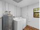 Functional laundry room with washer, dryer, water heater, and a view to the outdoors at 6464 Saint Anthony Dr, Meggett, SC 29449