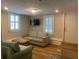 Inviting living room with wood floors, shuttered windows and comfortable seating arrangements at 65 Vanderhorst St # C, Charleston, SC 29403