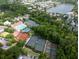 An aerial view shows the community's tennis courts, pools, and a serene lake surrounded by lush greenery and houses at 74 Hospitality St, Mount Pleasant, SC 29464