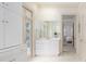 Bright bathroom with white cabinets, a vanity, french doors and a glimpse of the bedroom at 74 Hospitality St, Mount Pleasant, SC 29464