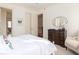 Bedroom view with a dark wood dresser, decorative mirror, and an elegant upholstered armchair at 74 Hospitality St, Mount Pleasant, SC 29464