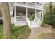 Inviting front porch with white columns, American flag, and well-manicured landscaping at 74 Hospitality St, Mount Pleasant, SC 29464