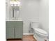 Charming bathroom featuring a green vanity with gold hardware, wood-look floors, and a toilet at 8340 Coventry Ct, North Charleston, SC 29420