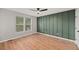 Bedroom with wood-look floors, natural light, and a decorative green accent wall at 8340 Coventry Ct, North Charleston, SC 29420